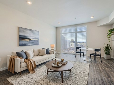 A living room with a couch, a coffee table, and a painting on the wall.