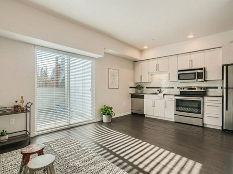 A modern kitchen with white cabinets and stainless steel appliances.