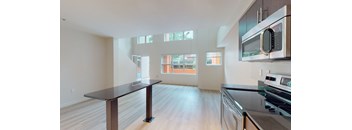 A kitchen with a black countertop and stainless steel appliances.