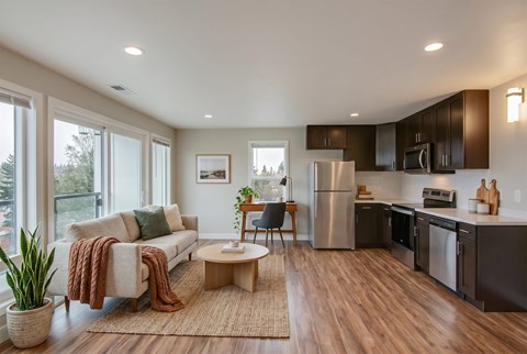 A modern kitchen with a refrigerator, microwave, and oven.