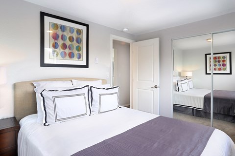 a bedroom with a large bed and a mirror