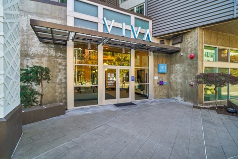 The entrance to a building with a glass door and a sign above it.