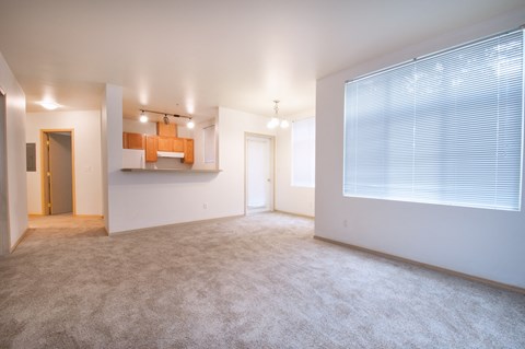 the living room and dining room of an apartment with a large window