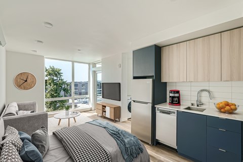 a bedroom with a bed and a kitchen with a sink