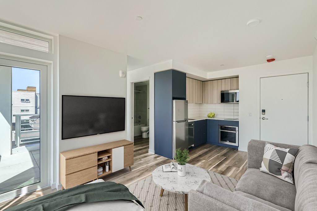 A modern living room and kitchen area with stylish furniture and open layout.
