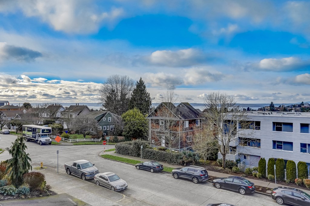 an aerial view of a neighborhood with cars parked in a parking lot