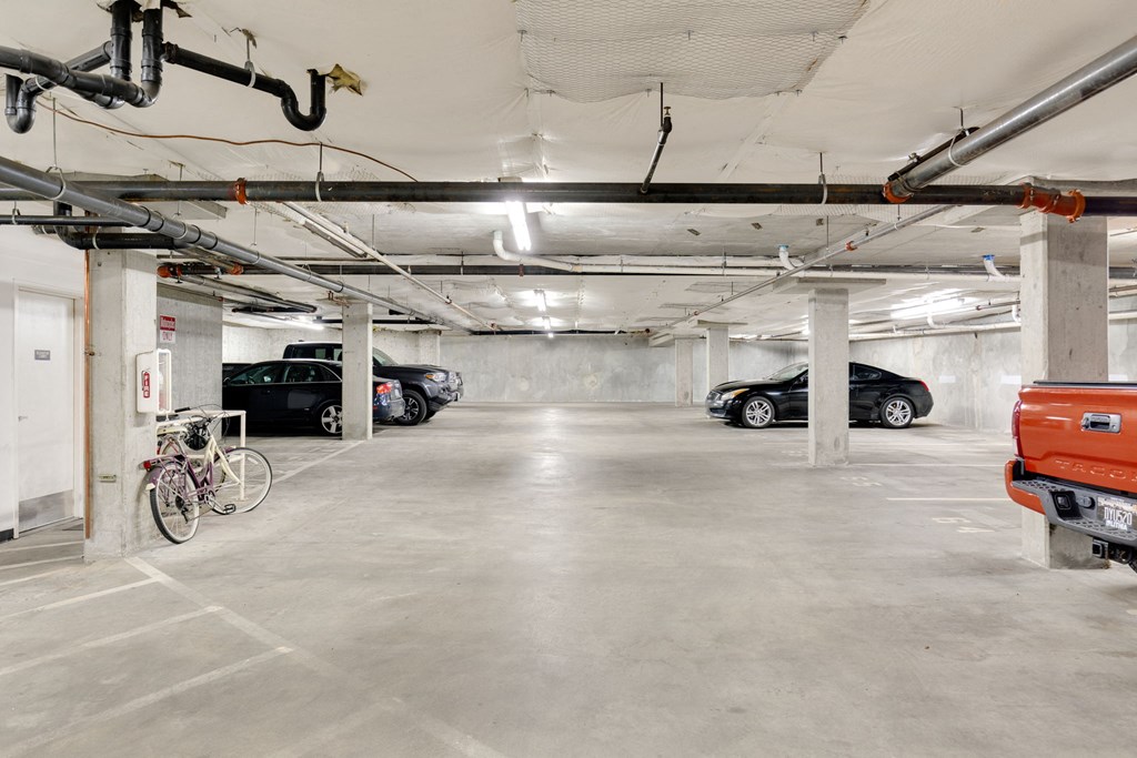 a parking garage with cars and a bike in it