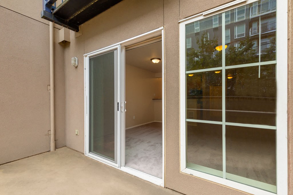 the entrance to a condo with a patio door and a large window