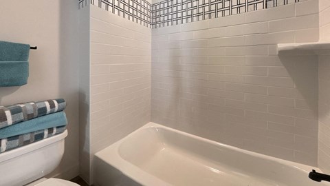 a bathroom with a white tub and a toilet