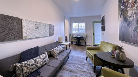 a living room with a couch and chairs and a dining room table