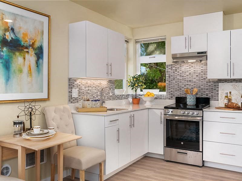 a kitchen with white cabinets and a table