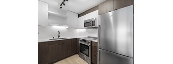 a kitchen with white cabinets and stainless steel appliances