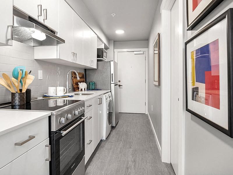 a white kitchen with a stove and a sink