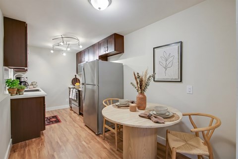 A kitchen with a table and chairs in the middle of the room.