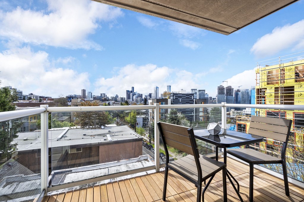 a balcony with a table and two chairs and a view of the city