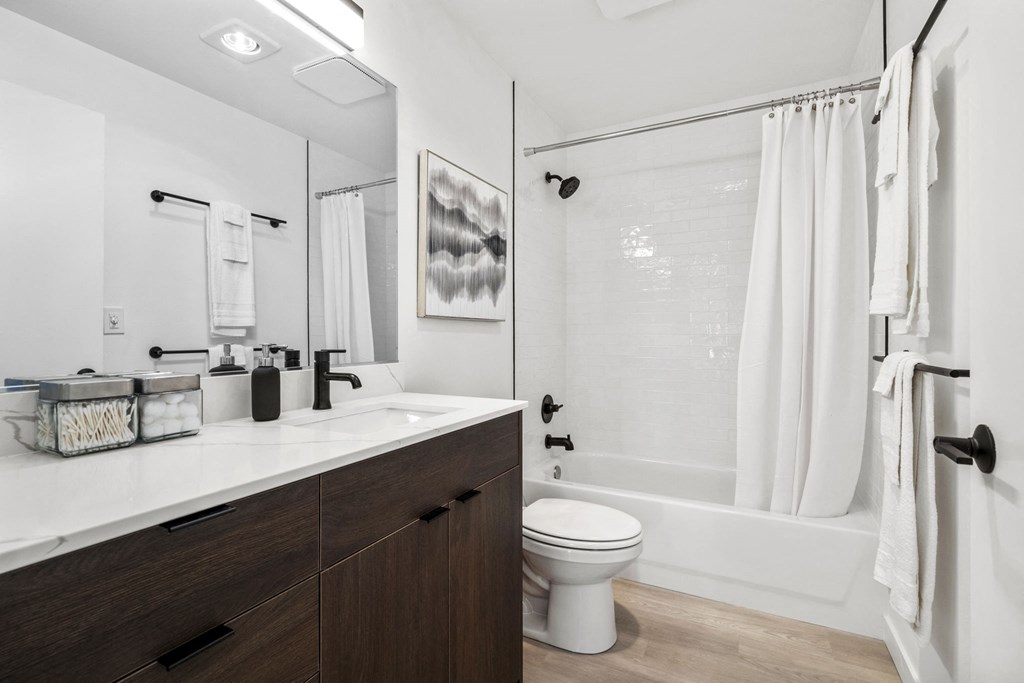 a bathroom with a toilet sink and shower in a 555 waverly unit