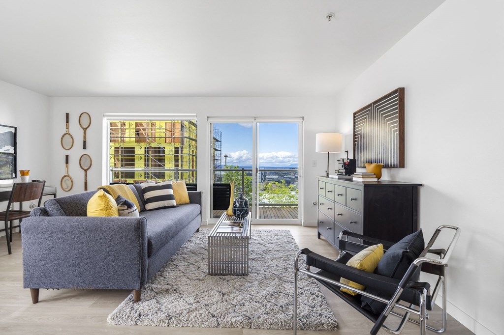 a living room with a gray couch and yellow pillows