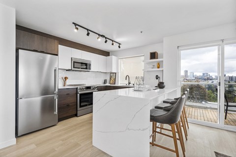 a kitchen with a large island and a stainless steel refrigerator
