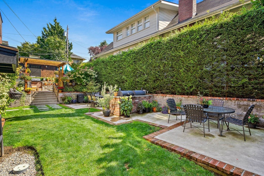 a patio with a table and chairs in a backyard