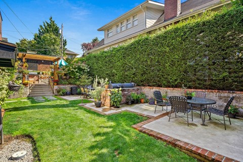 a patio with a table and chairs in a backyard
