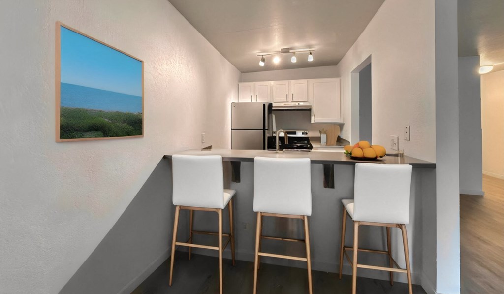 a kitchen with a bar with three stools