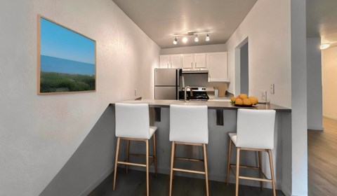 a kitchen with a bar with three stools