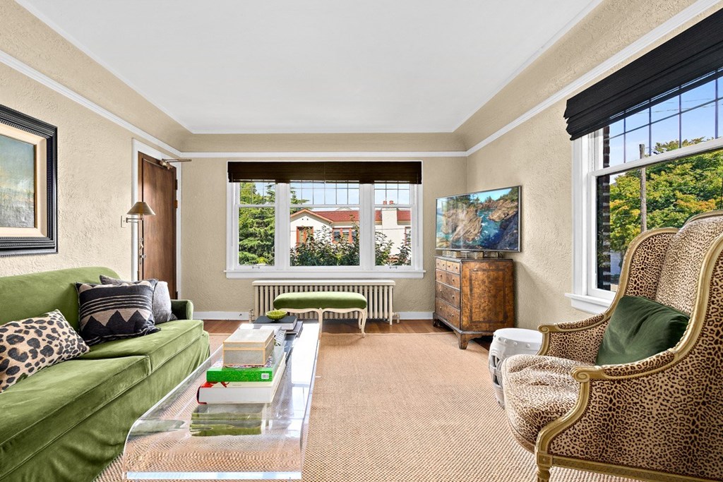 a living room with a green couch and a large window