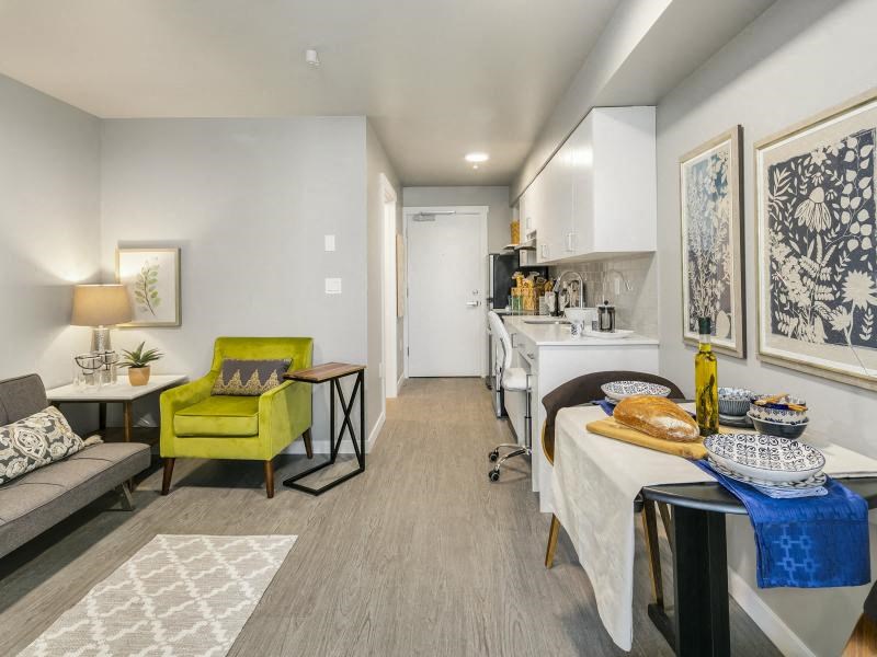 a living room and kitchen with a table with bread