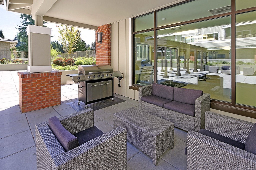 a patio with furniture and a grill