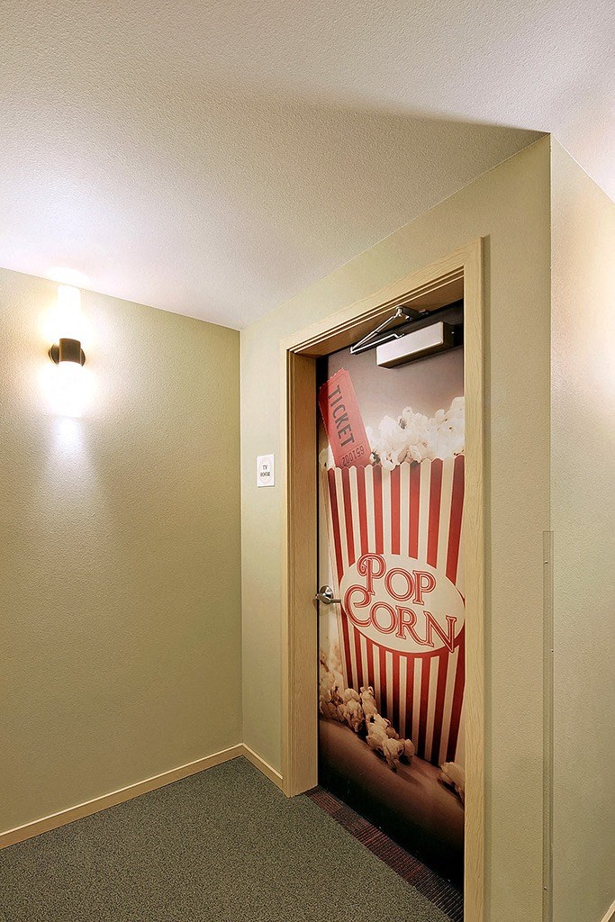 a door to a room with a popcorn advertisement on the wall