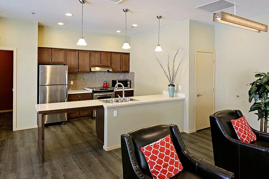 a kitchen and living room with a refrigerator and a sink