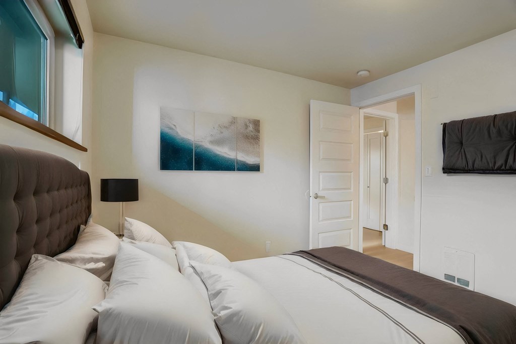 a bedroom with a large bed and a door to a bathroom