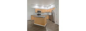 A kitchen with wooden cabinets and a stainless steel refrigerator.