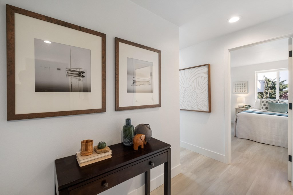 a bedroom with a dresser and two framed pictures on the wall