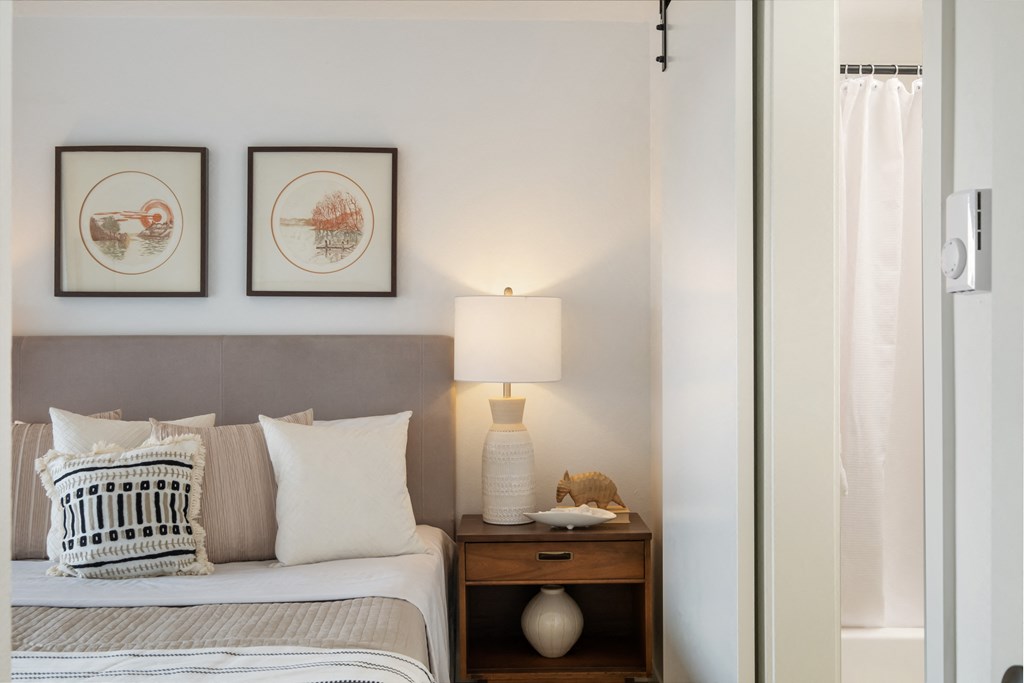 a bedroom with a bed and two pictures on the wall