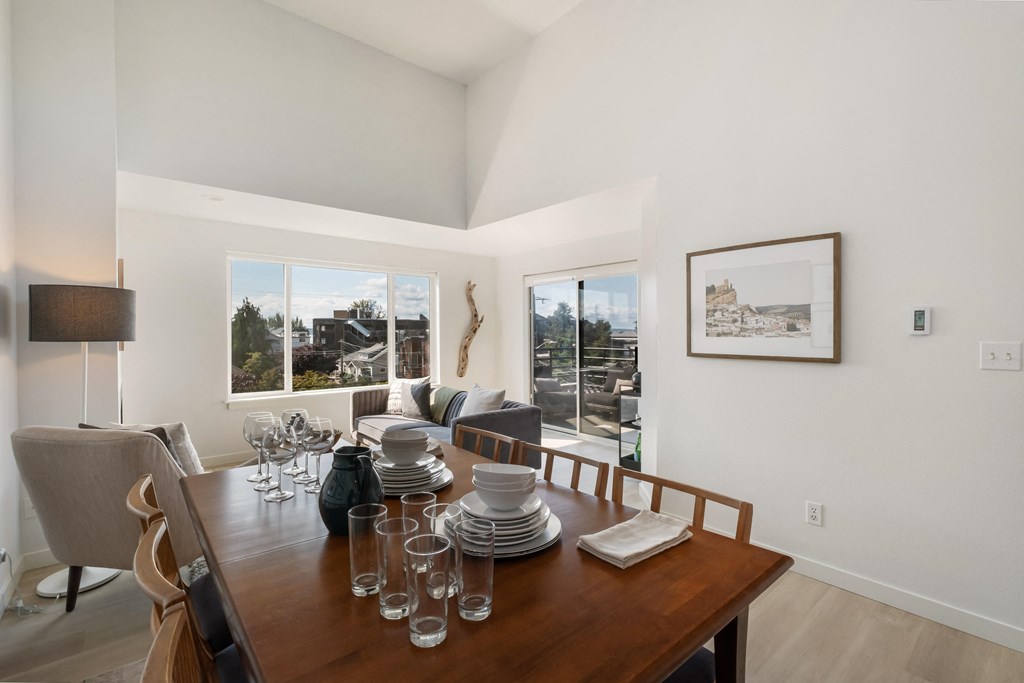 a dining room with a wooden table and chairs and a large window with a view of the