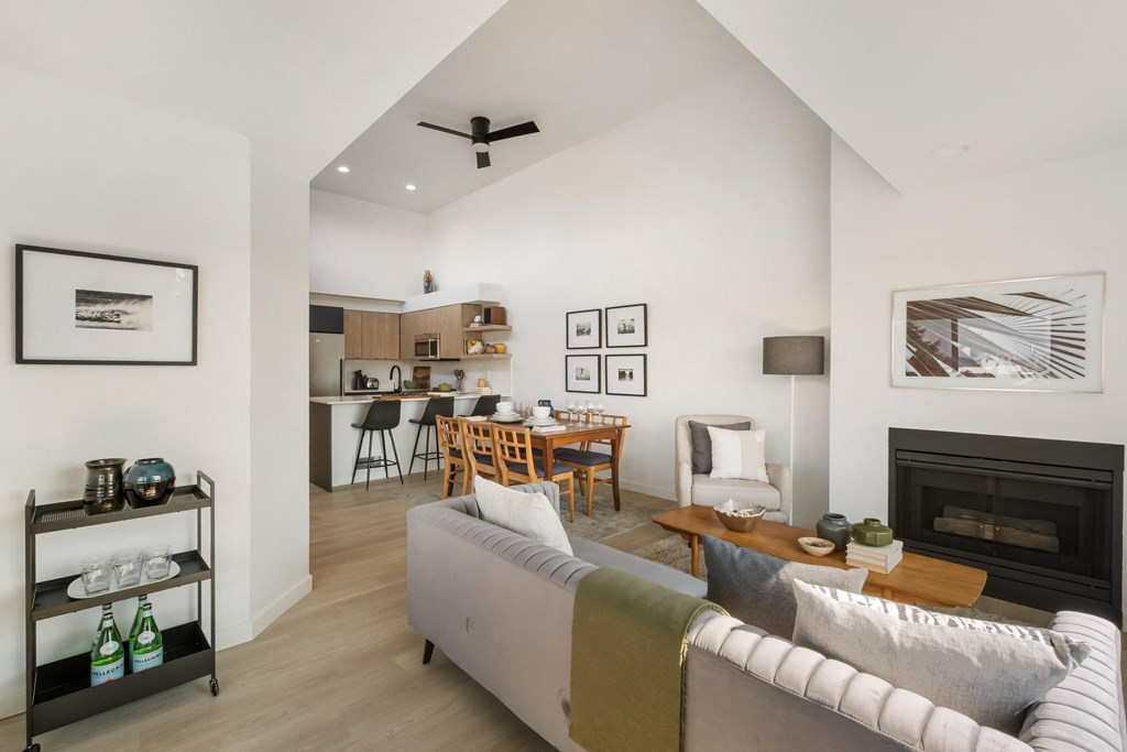 a living room with a couch a table with chairs and a fireplace