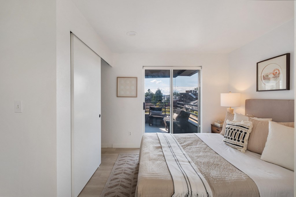 a bedroom with a bed and a door that leads to a balcony