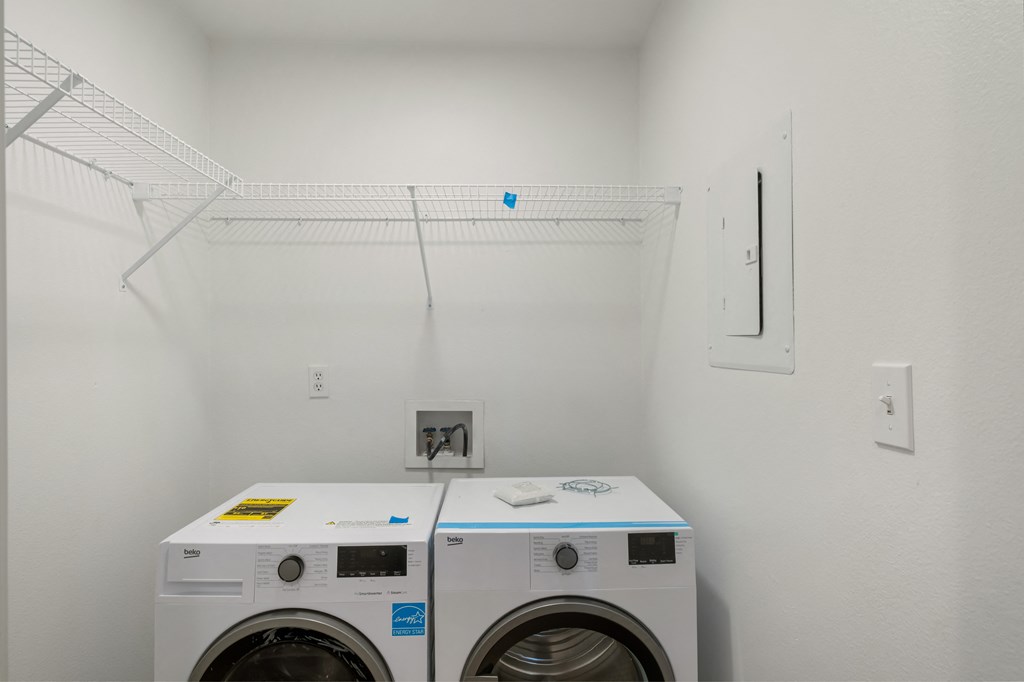 a laundry room with two washers and a dryer
