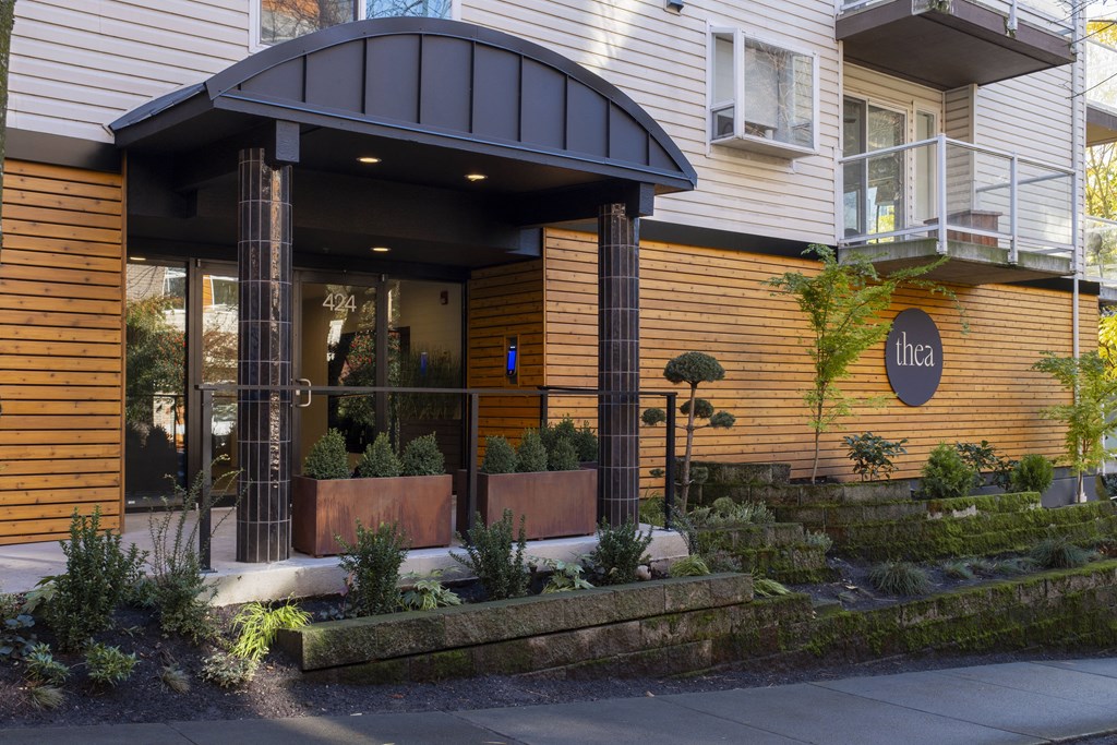 A building with a brown wooden exterior and a black awning.