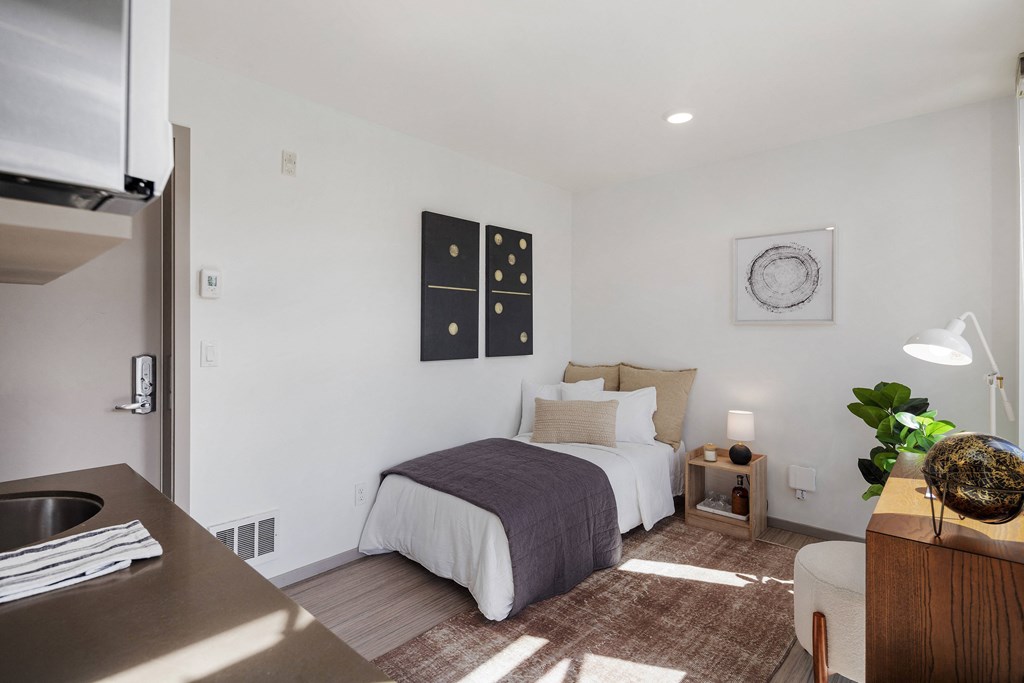 a bedroom with a bed and a desk in a small room