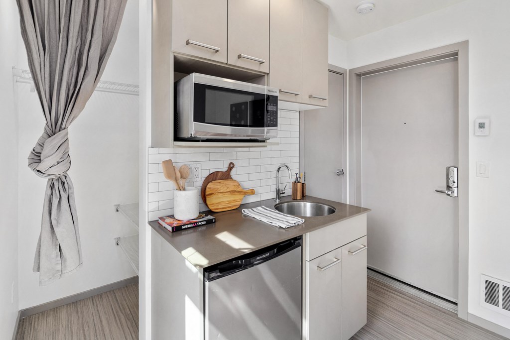 a small kitchen with stainless steel appliances and a microwave