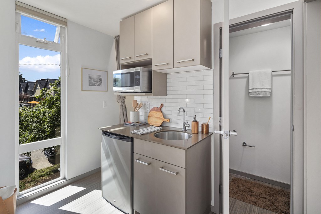 a small kitchen with stainless steel appliances and a window
