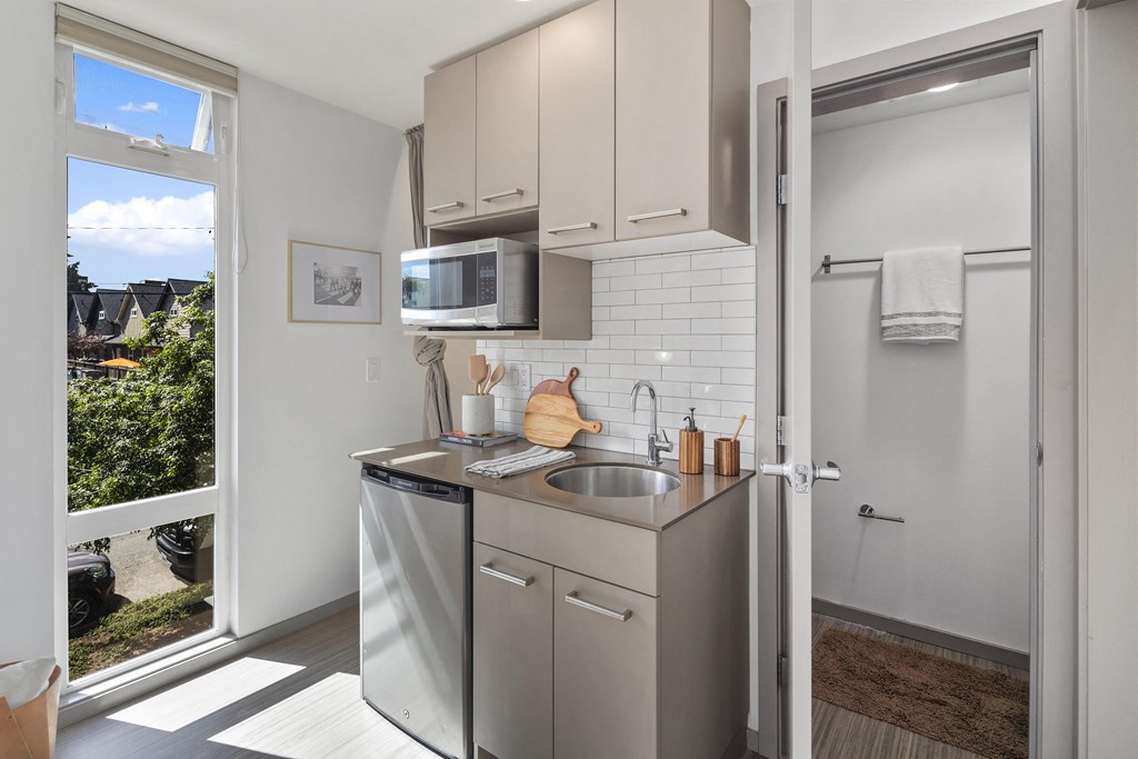 a small kitchen with stainless steel appliances and a window