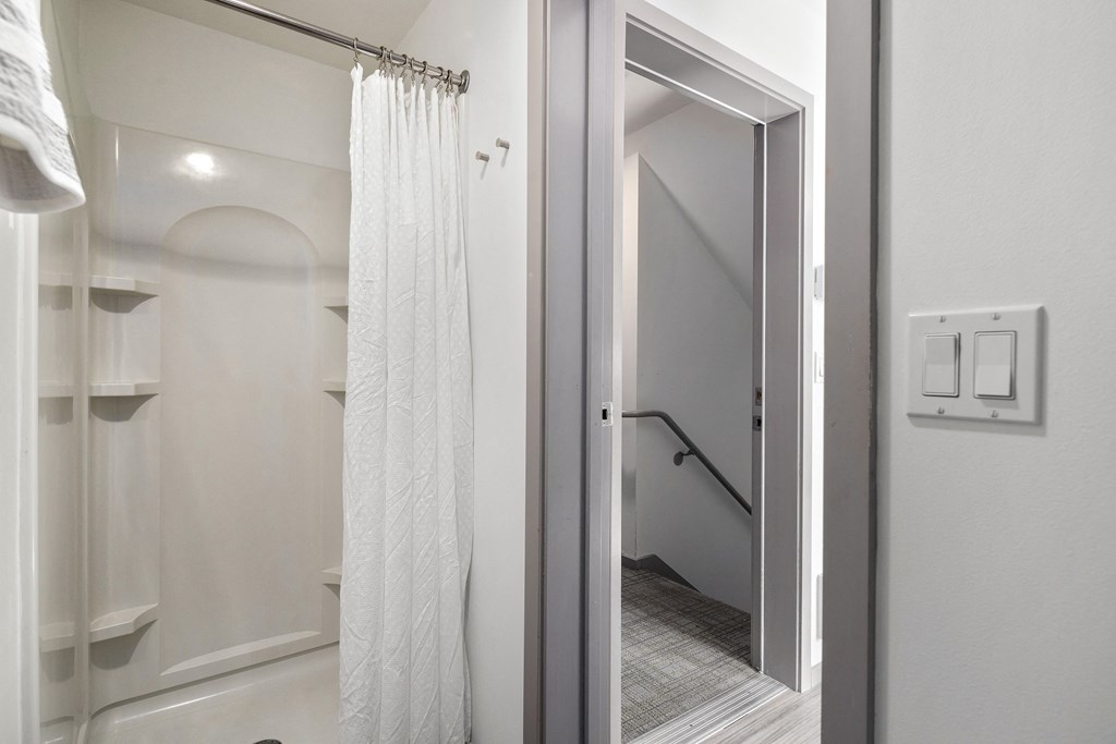 a bathroom with a shower and a staircase in a hotel room