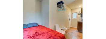 a bedroom with a bed and a closet and a white chair