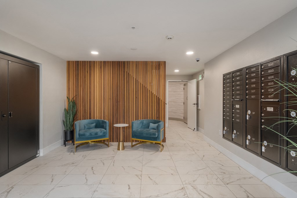 A hallway with two chairs and a wooden wall panel.