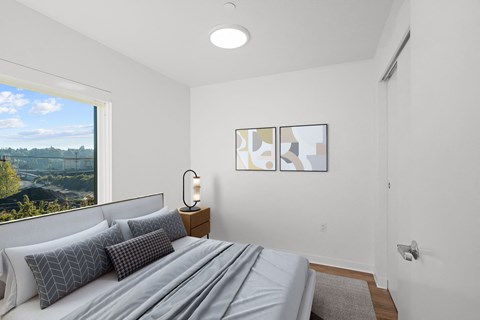 a bedroom with a bed and a large window