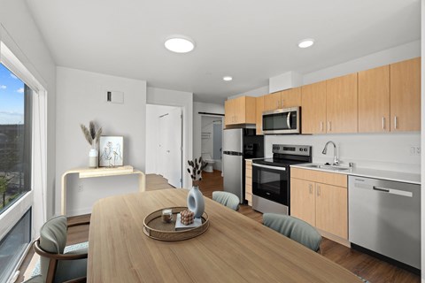 an open kitchen and dining room with a wooden table