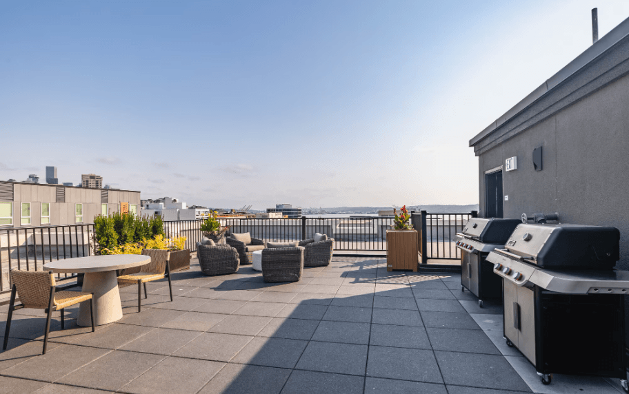 A patio with a table and chairs overlooking a body of water.